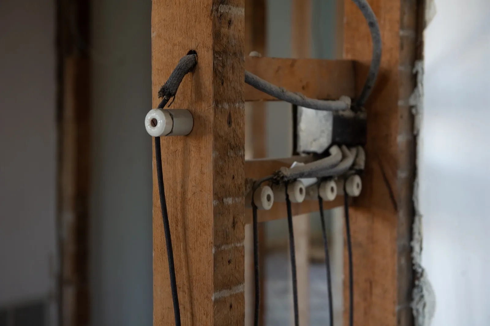 Knob-and-tube wiring with porcelain insulators exposed in the wall of an older Milford, MA home during rewiring